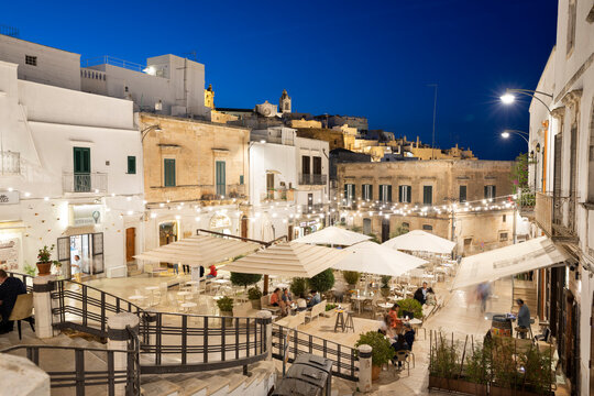 Restaurants lit up in the evening in Piazza della Liberta, Ostuni, Brindisi province, Puglia