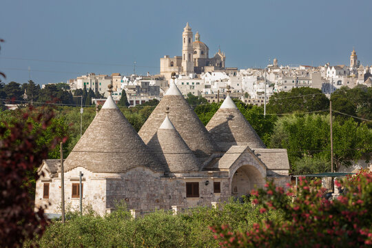 Locorotondo town and Chiesetta Rettoria Maria SS Annunziata church on hilltop with trulli house below in the Valle d'Itria, Locorotondo, Puglia