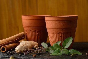 Earthen tea cup or Chai in kulhad with Ginger, Cardamom  Cinnamon tulsi - obrazy, fototapety, plakaty