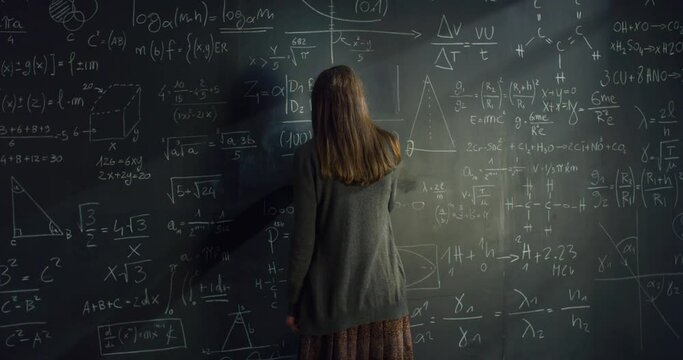 Back View: Woman Writing Mathematics Formulas with Chalk on a Blackboard, Getting Frustrated and Wiping it with Anger. Female Scientist Trying to Solve Equations, Feeling Angry When She Gets Stuck