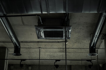 Black ventilation system pipes on the concrete ceiling. Air conditioning system in the modern industrial loft interior