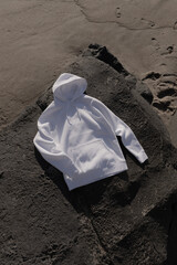 MOKITUP: Top-View Isolated Folded Raglan Sleeve Hoody Mockup on Beachside in sand and Rocks 