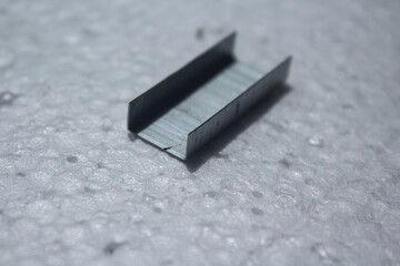portion of metal staples on a white background