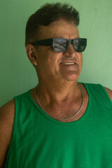 Obraz premium Portrait of a mature man wearing sunglasses and a green shirt