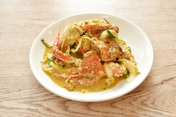 stir fried swimmer crab in yellow curry and egg on plate
