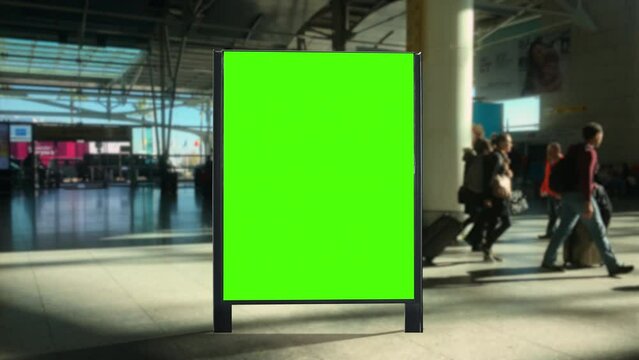 Airport Panel Green Screen People Walking Behind Billboard. Panel green screen inside an airport with people walking behind. Pre Keyed