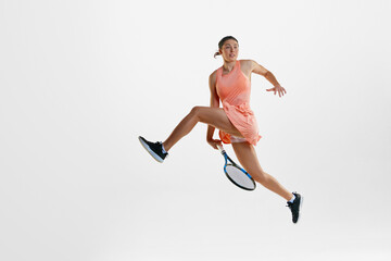 Dynamics and motions. Young female athlete, professional tennis playing in uniform training against white studio background. Concept of professional sport, movement, health, action. Ad