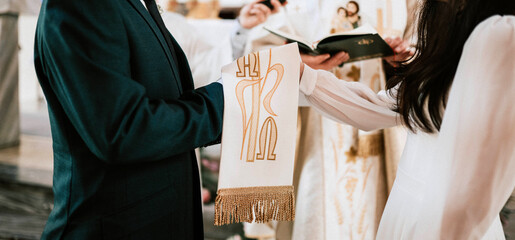 Zakładanie obrączek ślubnych w kościele podczas ślubu przez parę młodą