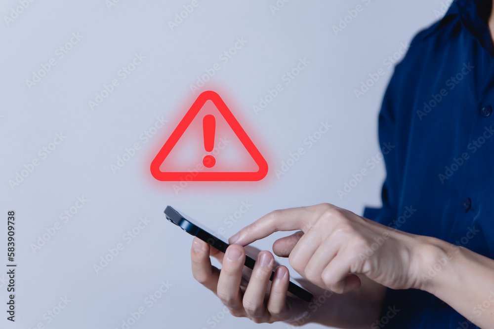 Wall mural businessman using smartphon showing warning triangle and exclamation sign icon caution of dangerous 