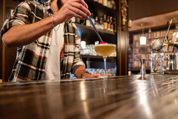 man hand bartender making cocktail in glass on the bar counter