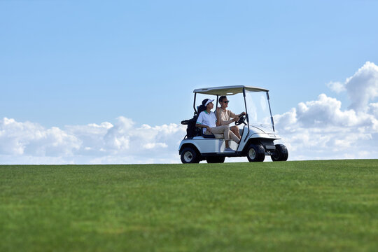 Minimal background image of sporty couple driving golf cart across field with center line horizon, copy space