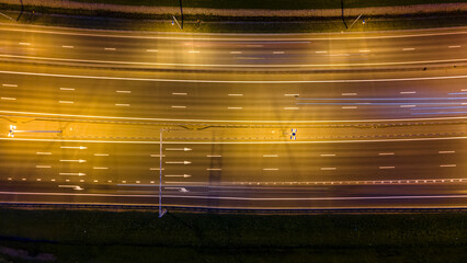 Aerial down view of the bigger highway with many cars next to forest and the historical and at same...