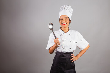head chef, Brazilian cook, from the Northeast, holding a metal spoon for preparing food, stews and...