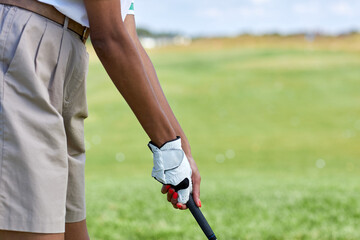 Close up of unrecognizable young woman playing golf outdoors focus on female hands holding golf club, copy space