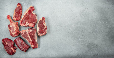 set of various uncooked stakes t bone tomahawk sirloin ribeye beef on a light background. banner,...