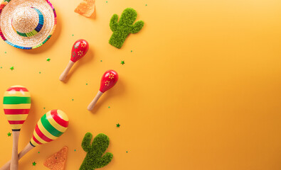 Cinco de Mayo holiday background made from maracas, cactus and hat on yellow background.
