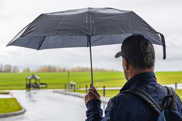 man holding an umbrella being outdoors in the rain