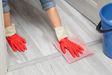 man wipes the door sill while cleaning the house