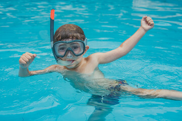 Menino na piscina com óculos de mergulho