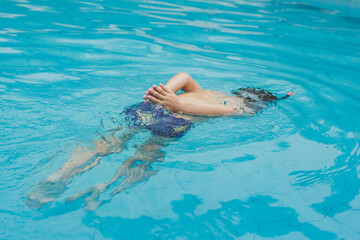 Menino brincando na piscina no verão