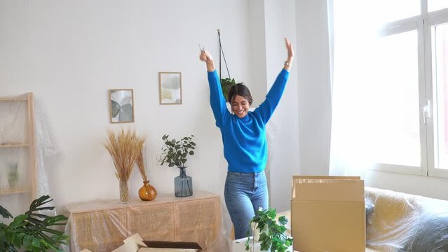 Happy woman with raised arms in new apartment