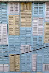French Colonial shutters cover a building facade in Ho Chi Minh City, Vietnam.  A very strange terrace house.