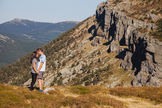 Couple of travelers standing against mountain slope