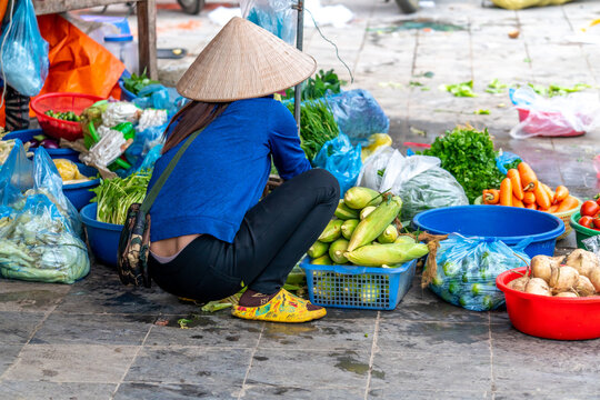 Northern Vietnam, a woman sells fruits and vetebales at the street  market.