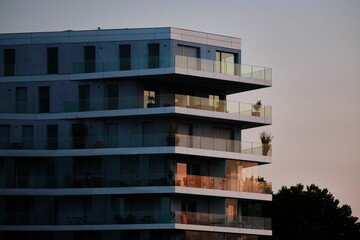 Beautiful view of a modern futuristic building with multiple apartments at sunset