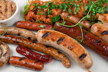 Grilled different sausage with the addition of herbs and horseradish sauce on the plate. Grilling food, bbq, barbecue concept