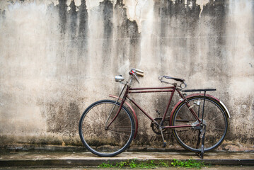 Vintage bicycle on old rustic dirty wall house, many stain on wood wall. Classic bike old bicycle...