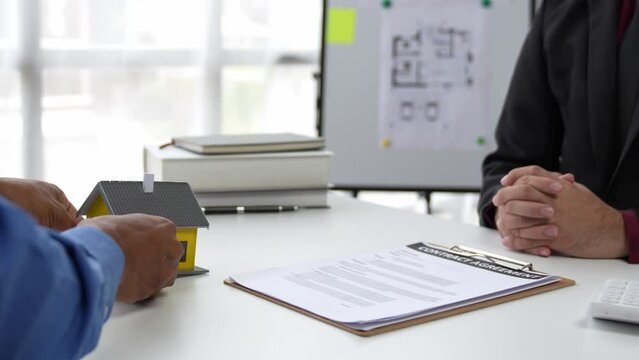 Real estate agent or sales manager has offered home sales and explained the terms of signing the house purchase contract and free home insurance, Finance and after-sales service concept.