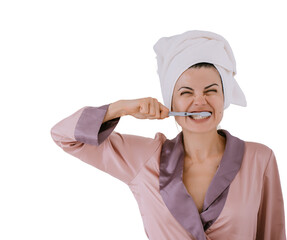 Annoying young adult woman in silk robe and towel wrapped around head brushing teeth against...