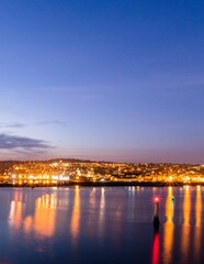 Nighttime view of the seaside port of Teignmouth from across the river Teign in Shaldon