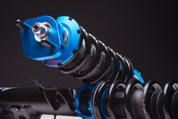 auto suspension tuning coilovers shock absorbers and springs blue for a sports drift car on a dark background - obrazy, fototapety, plakaty