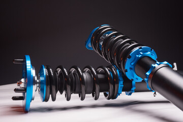 auto suspension tuning coilovers shock absorbers and springs blue for a sports drift car on a dark background - obrazy, fototapety, plakaty