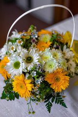 A beautiful bouquet of gerberas and wildflowers in a white basket.