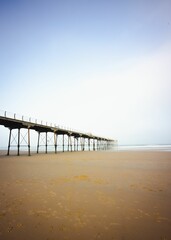 Fototapeta na wymiar Vertical shot of the pier at the seaside town of Saltburn-by-the-Sea on a misty day, North Yorkshire