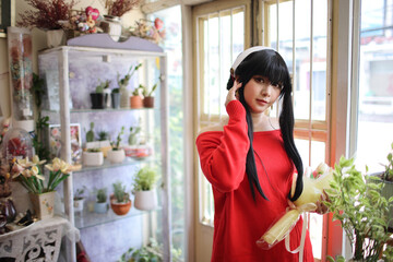 Portrait of a beautiful young woman Cosplay with red sweater at flower shop