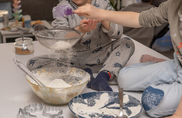 children adding flour to a cake mixture