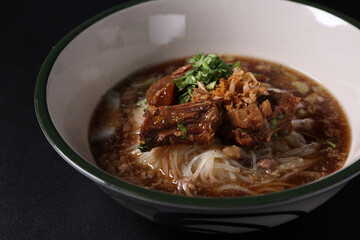 Braised pork noodles Thai street food isolated in black background