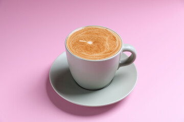 hot cappuccino with latte art isolated in pink background