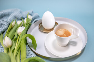 cup of coffee with white tulips and egg candle