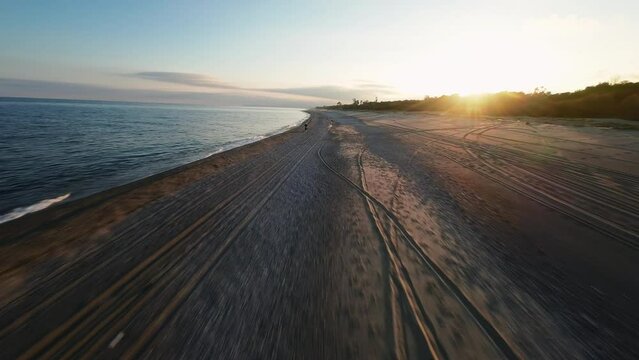 Aerial tracking of motocross on the beach near the ocean with fpv