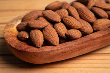 Almonds in a wooden bowl on a wooden table
