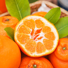 Fresh juicy clementine in wooden box. whole or half cut