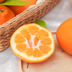 Fresh juicy clementine in wooden box. whole or half cut