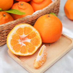Fresh juicy clementine in wooden box. whole or half cut