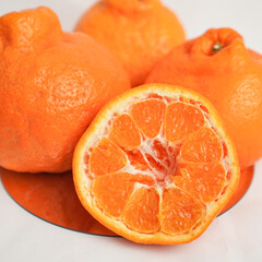 A set of oranges put together on a white table.