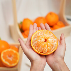 Cut part of orange fruit in human hands